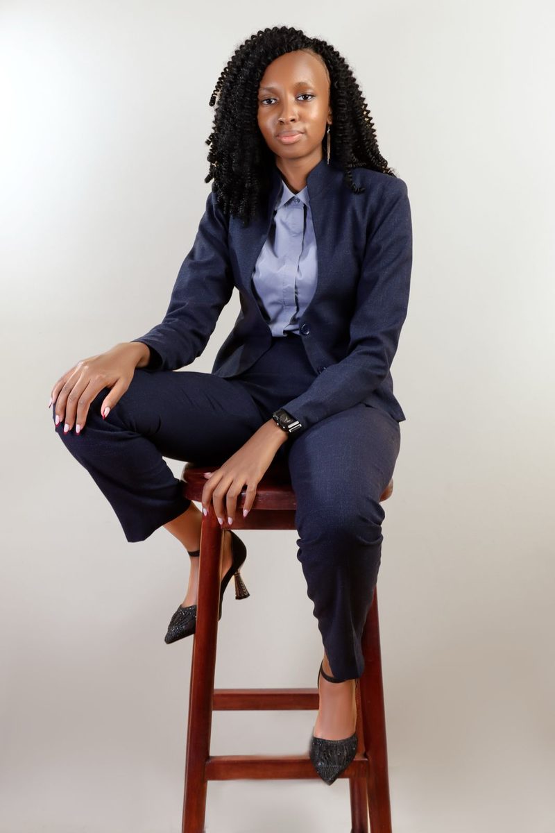 Susan Wakarindi seated, in a navy suit